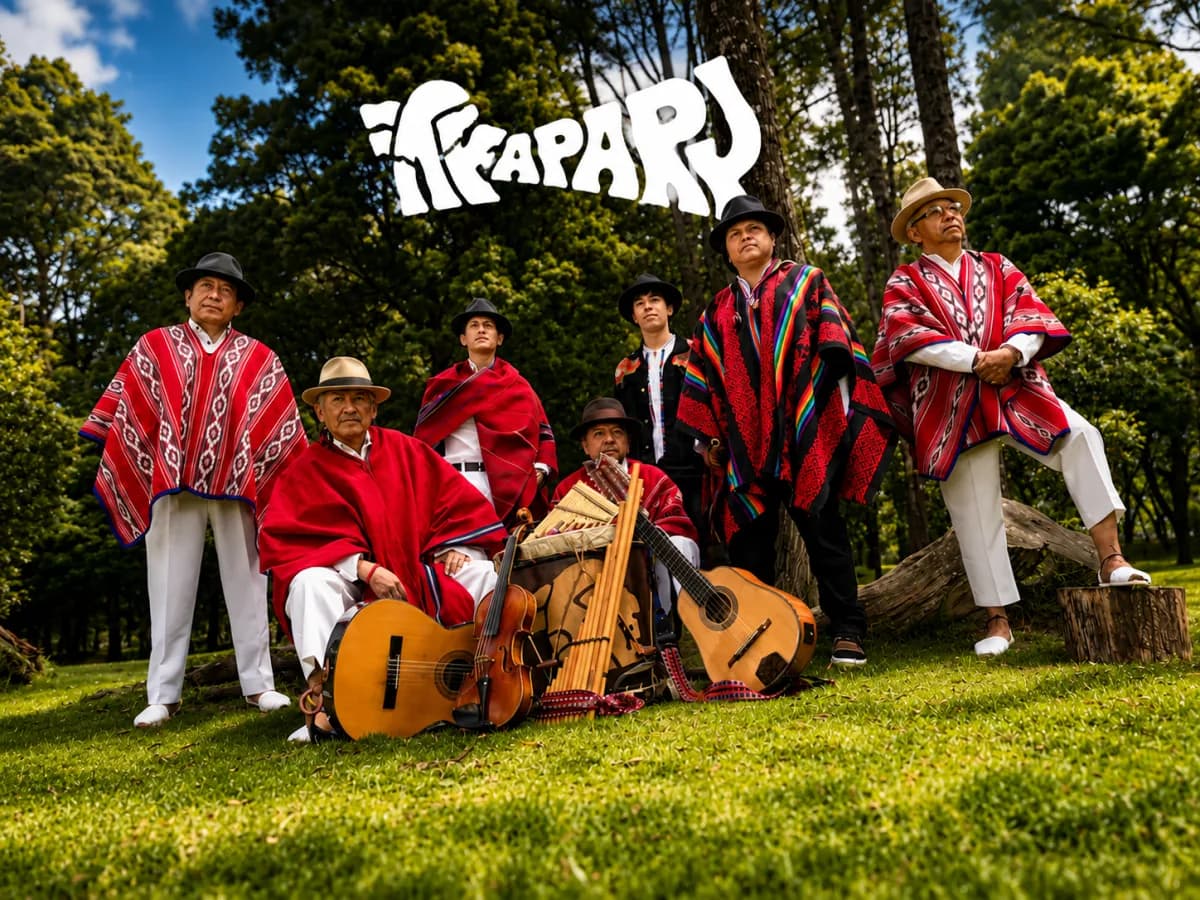 Seven Kapary musicians gathered outdoors beneath the Kapary logo