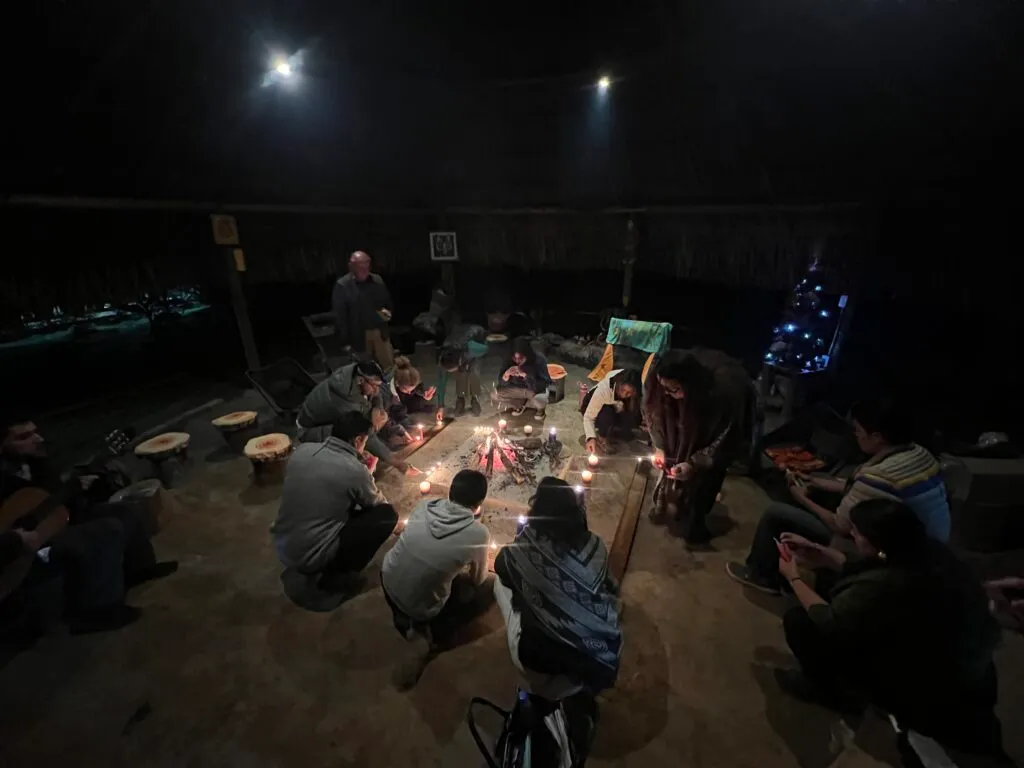 Participants gathered around the fire in the Camino al Sol bohío